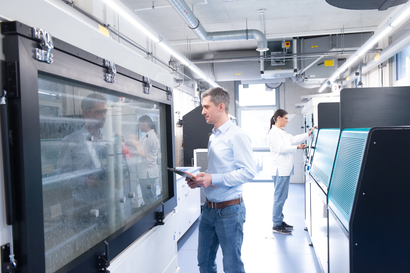Materialingenieur prüft ein beschichtetes Bauteil an der Klimawechselkammer im IFO-Prüflabor
